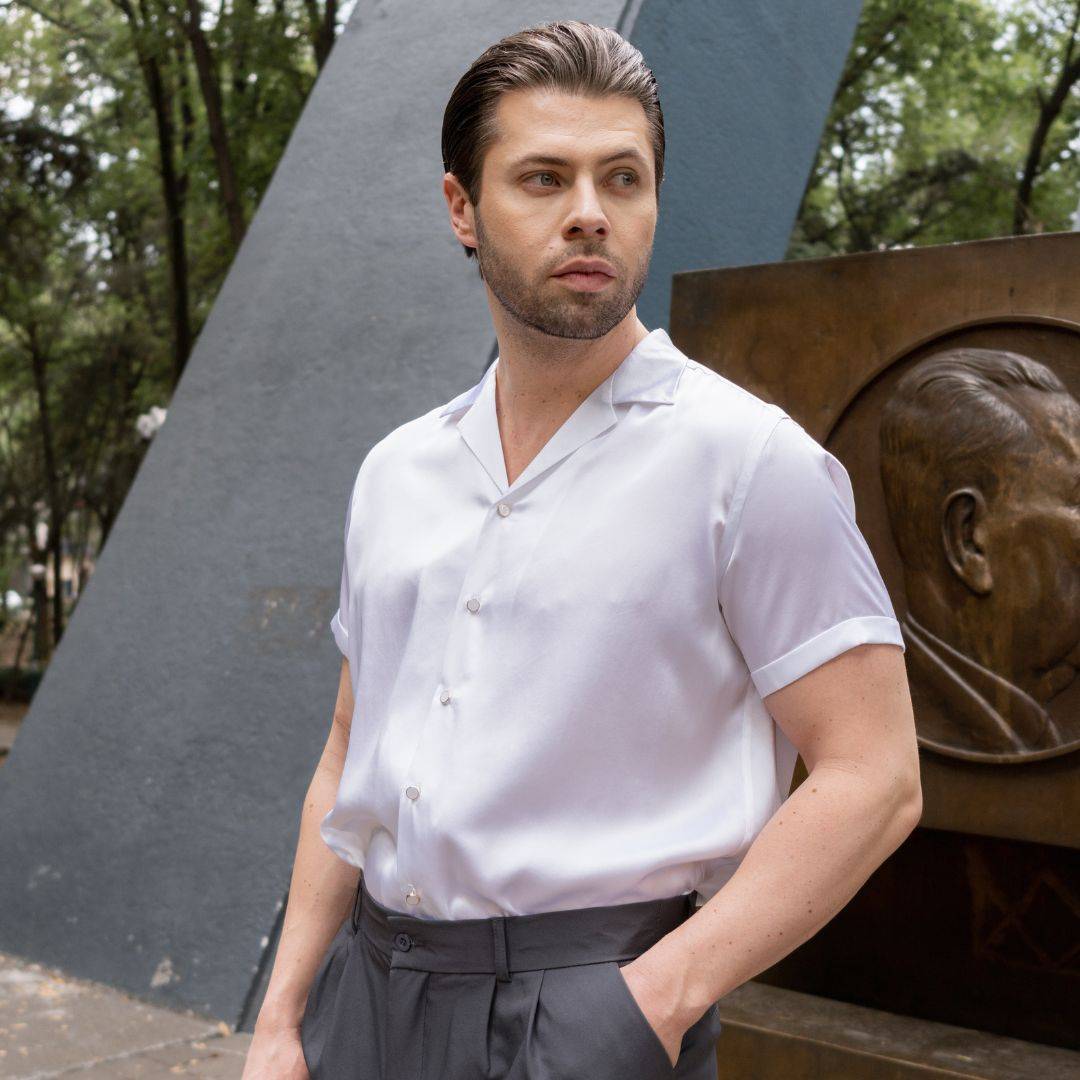 model wearing grey high rise pants and a tucked in short sleeve white silk shirt from 1000 kingdoms
