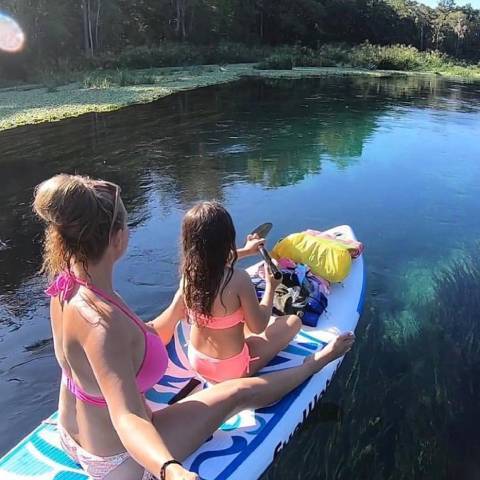 Customer with her kid sitting in top rated blow up paddle boards