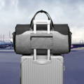 空港でスーツケースのハンドルにベルトで固定されているボストン型ガーメントバッグ「マドリード」（Madrid） - ブロデリック（Broderik）