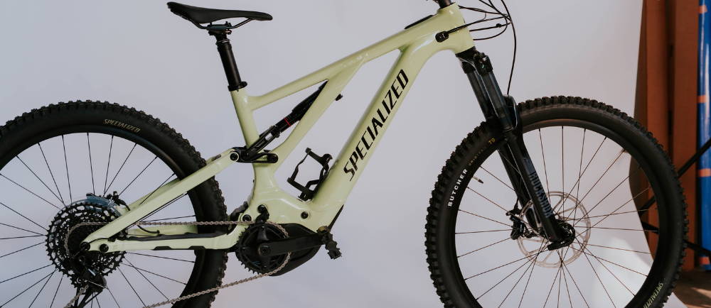 A white Specialized Turbo levo full suspension electric bike on a white background
