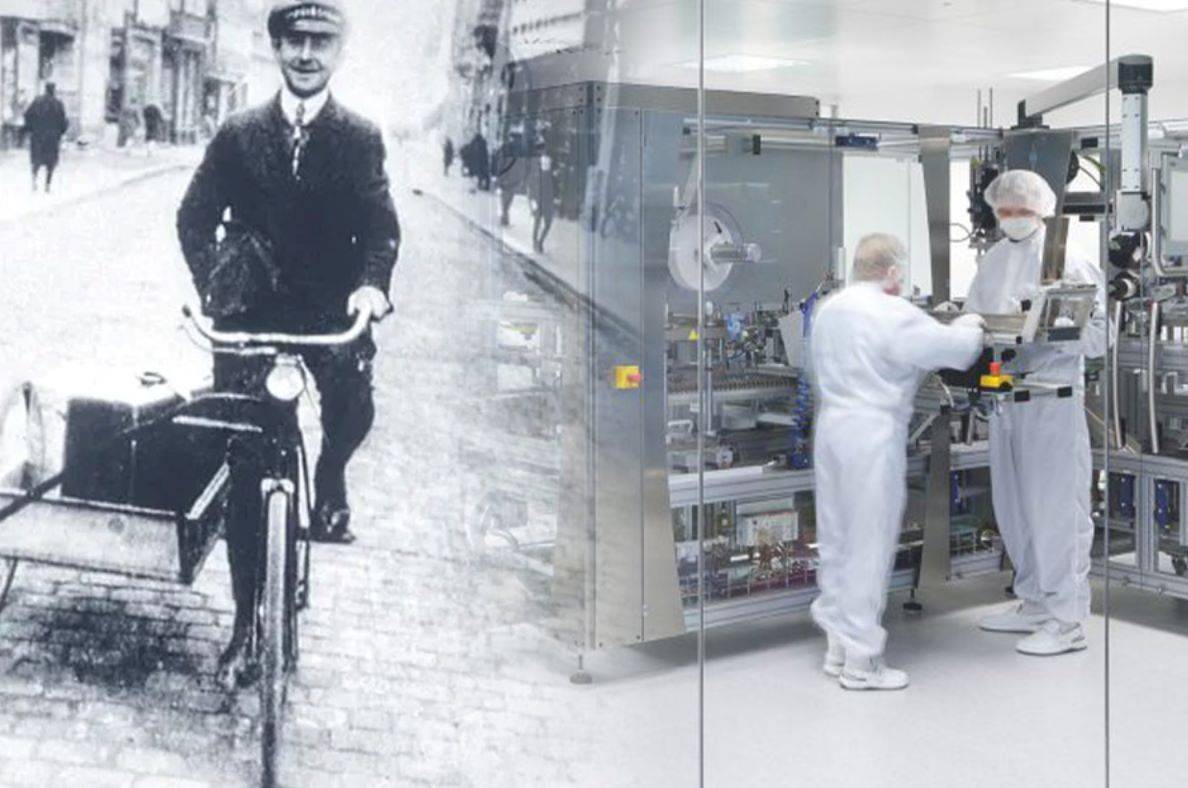 man driving old fashion bike blending into modern factory environment