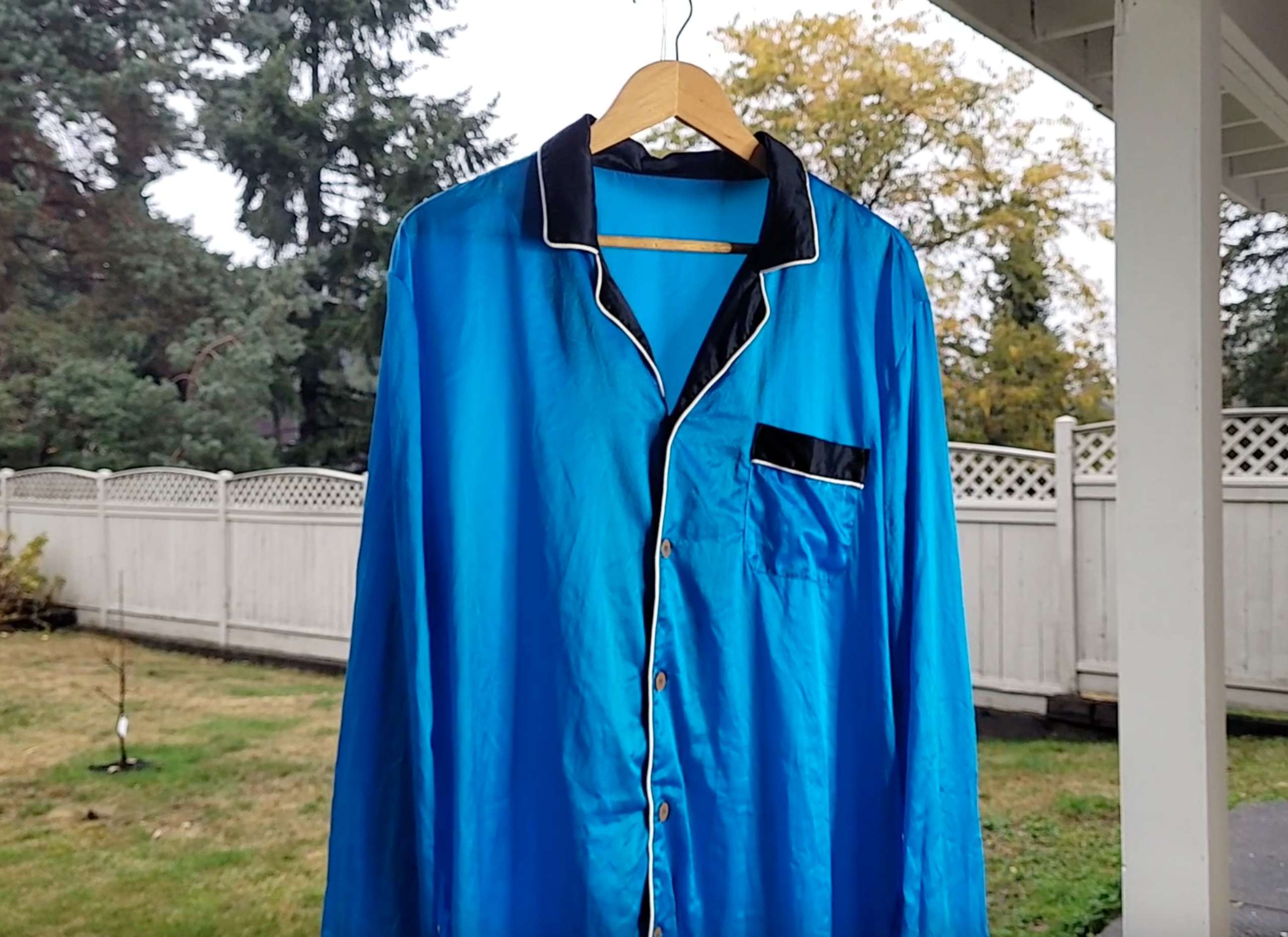 a picture of a blue silk shirt hanging outside in the shade to air dry