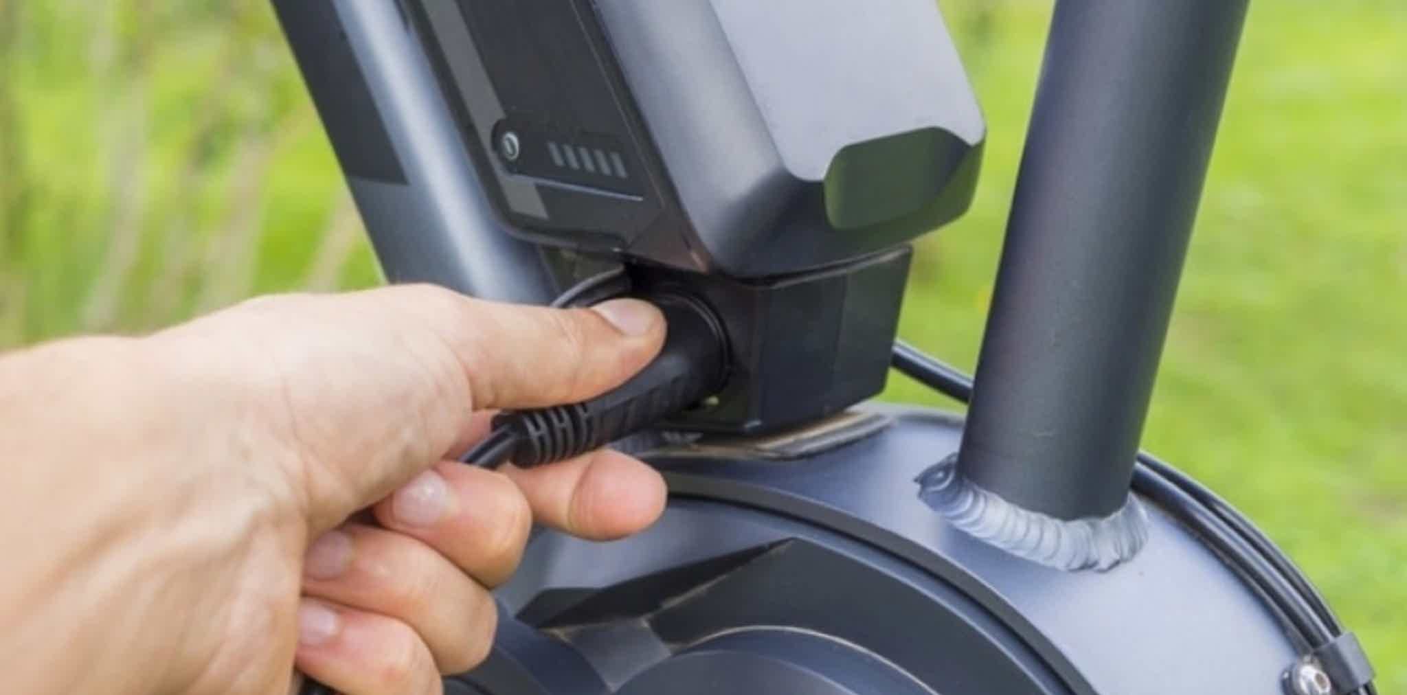 Imagen de recurso de una persona cargando la batería de una e-bike.