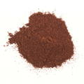 Reddish brown powdered chiles sitting on top of a white background