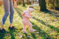 Toddler taking independent first steps barefoot in a safe Montessori-inspired bedroom environment