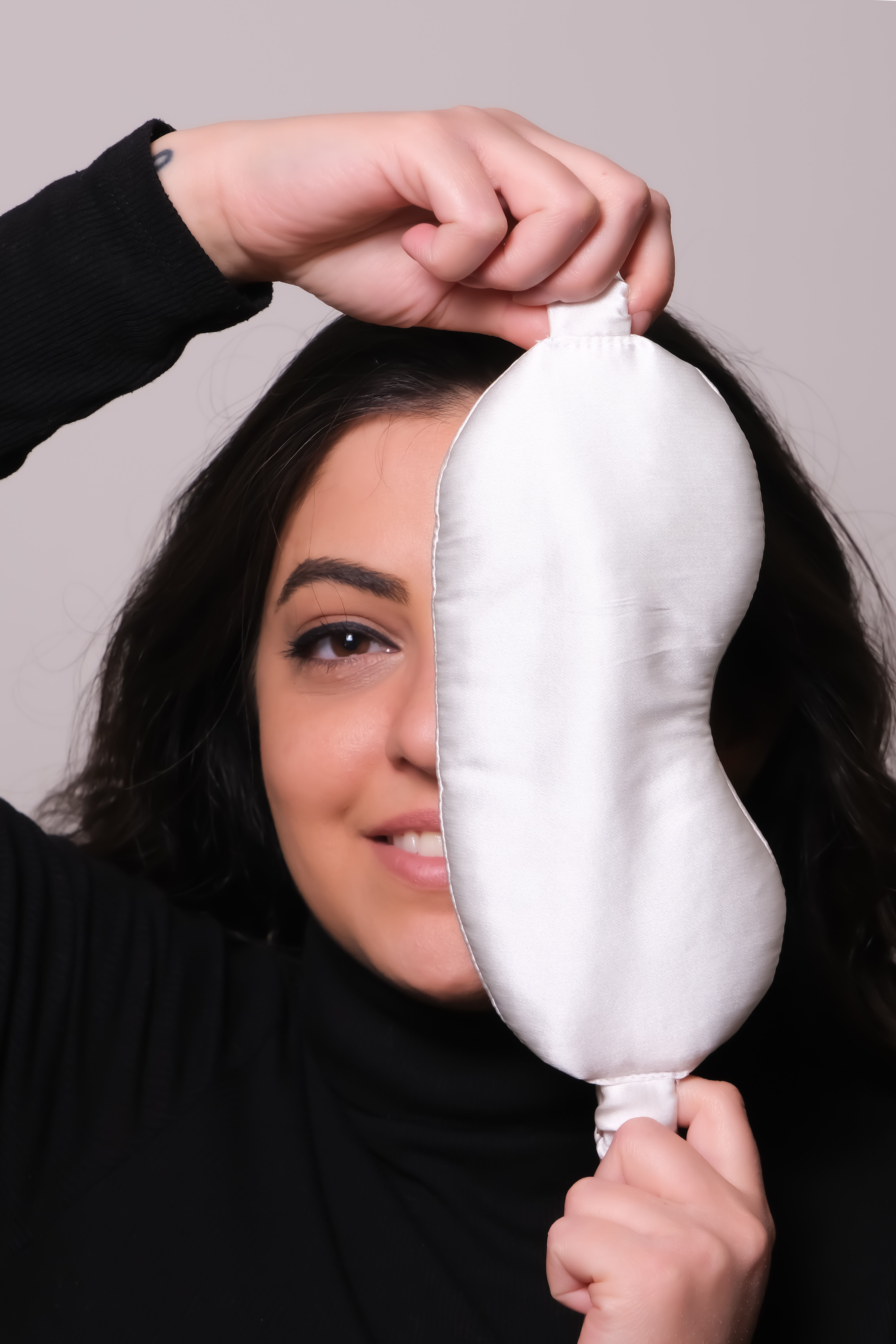 Woman holding a white silk sleep mask