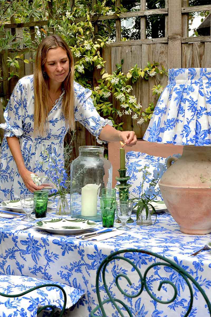 Alice Palmer wears YOLKE's Tiered Silk Evie Dress whilst setting the made to match table