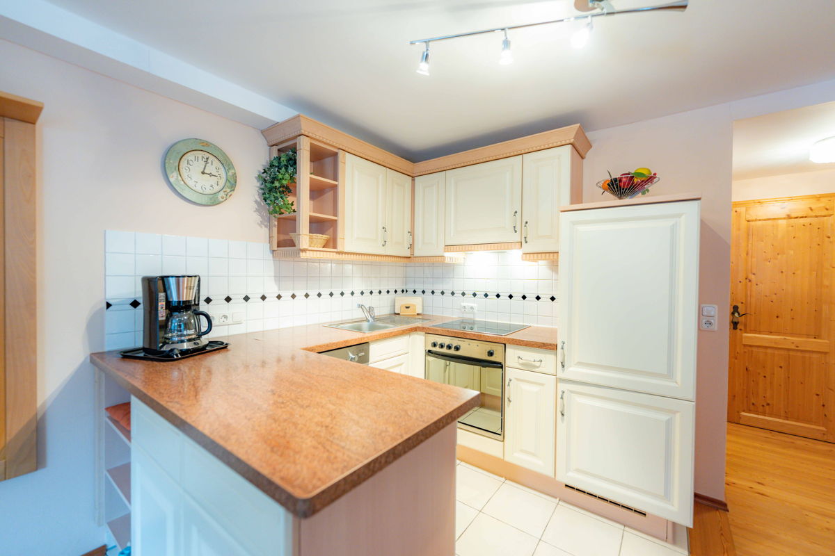 Offene Wohnküche mit Holzarbeitsfläche im Apartment.