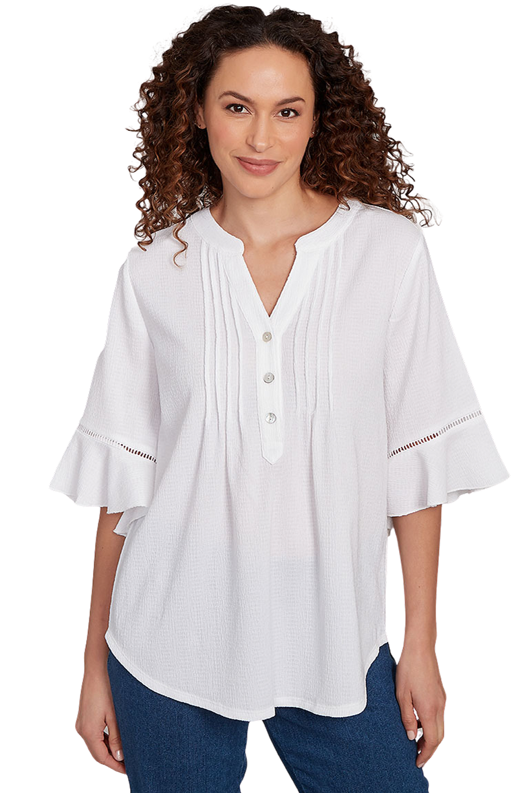 A woman wears a white pleated bell sleeve top.
