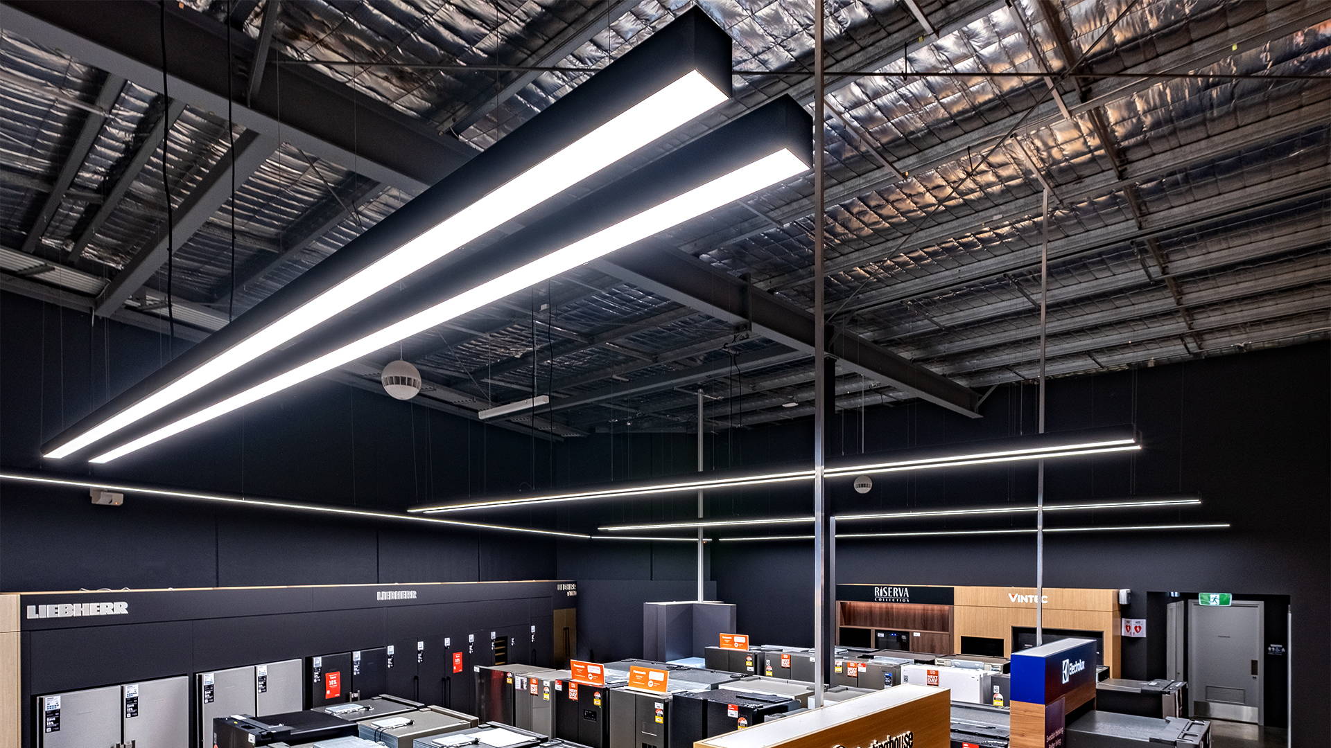 Havit Commercial lighting installation showcasing track and pendant lights used to define zones, highlight merchandise and maintain a clean ceiling aesthetic.