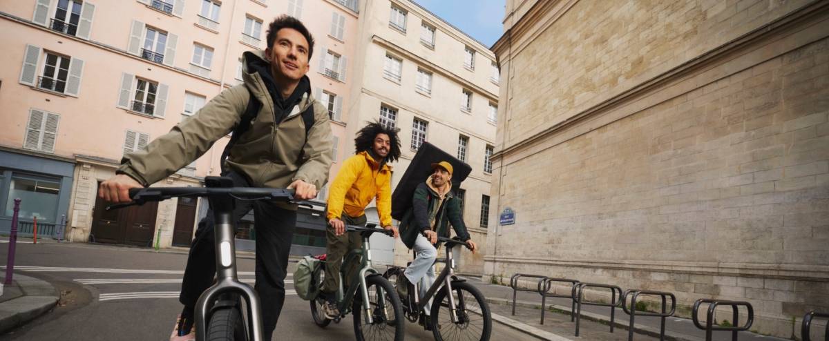 Trois jeunes cyclistes se rendent au travail à vélo électrique en ville