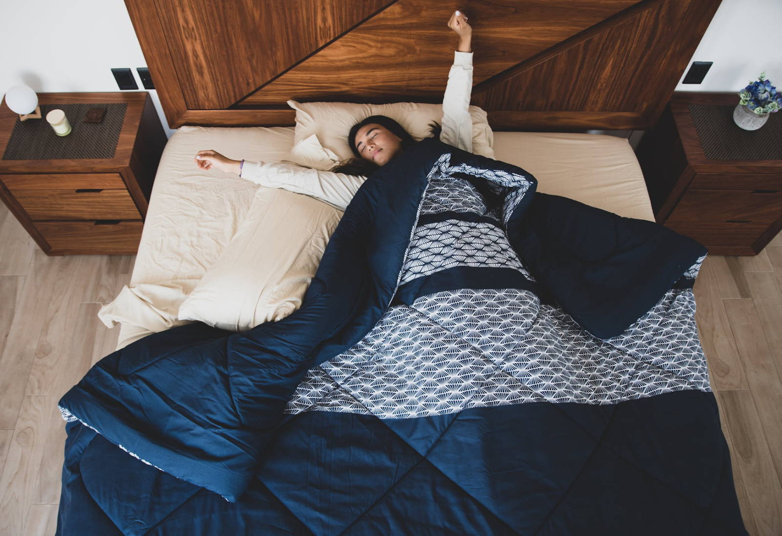 Woman stretching and relaxing in bed under a blanket - Photo by Los Muertos Crew from Pexels