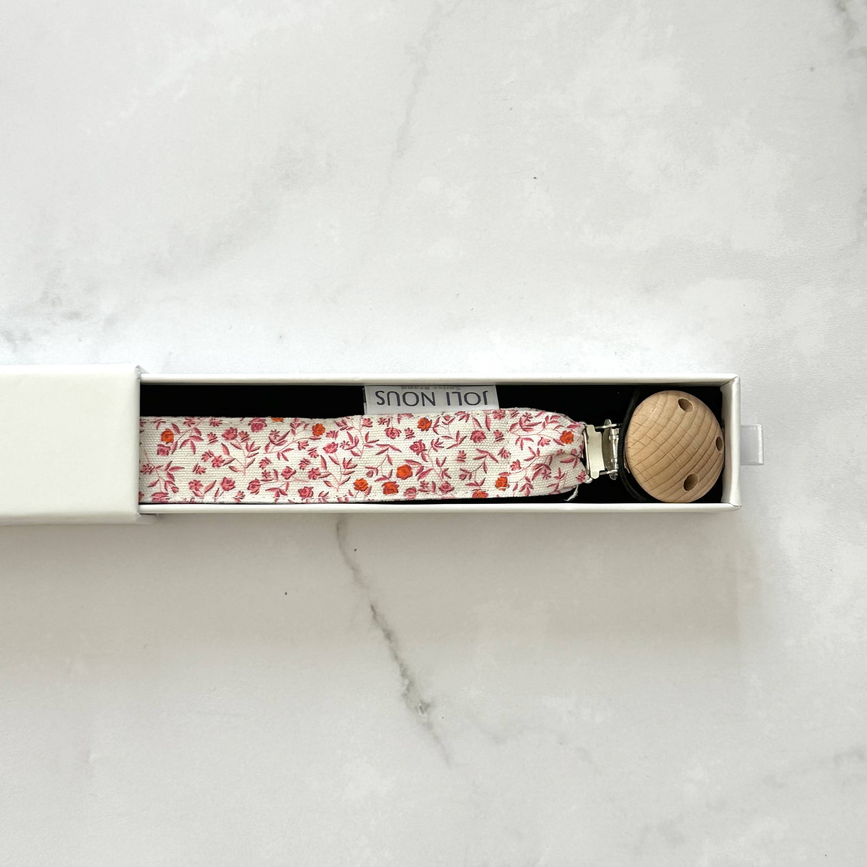 Attache-tétine fraises rouge blanc élégant de la marque suisse 'Joli Nous', un accessoire premium pour bébé, alliant design raffiné et qualité exceptionnelle