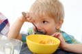 Little boy eating cereal for breakfast. 