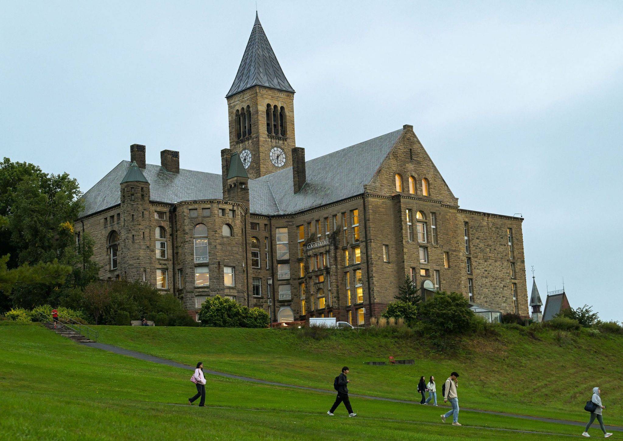 Cornell university building with students walking.