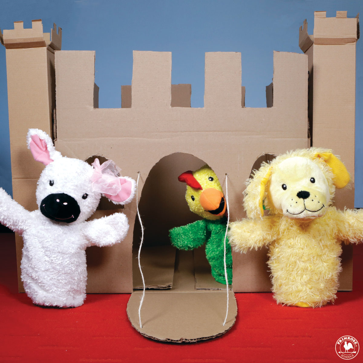 Primrose puppet Percy the chicken peeks out from a cardboard castle while Libby the lamb and Erwin the dog stand outside