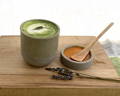 Garden matcha latte in a ceramic cup and honey and lavender on the side on a wooden tray