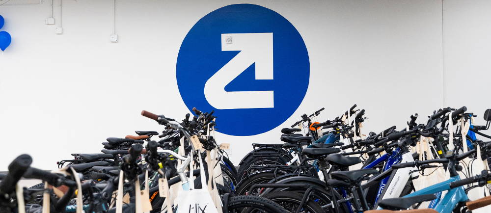 The Upway logo on a wall behind bikes