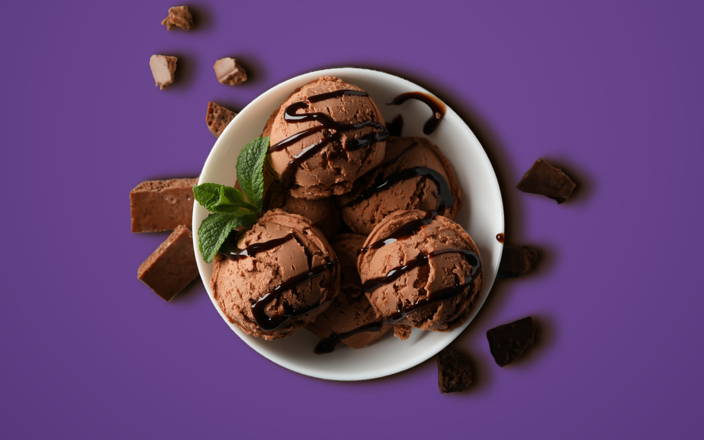 Chocolate ice cream in a bowl with chocolate sauce drizzled on top for Confetti's Virtual Ice Cream Making Class