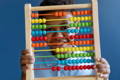 African-American boy holding a wooden abacus.