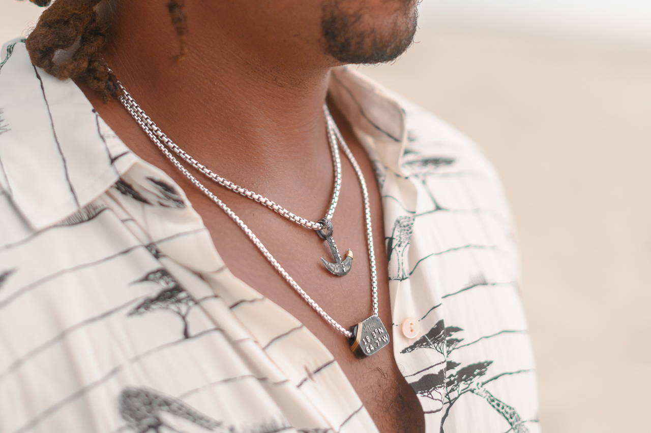 Man wearing Vibe Jewelry Caribbean-inspired pendants.