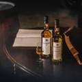 Bouteilles de Single Malt Scotch Whiskies posées sur une table en bois avec verre de dégustation à la distillerie Clynelish dans le nord-ouest des Highlands d'Ecosse