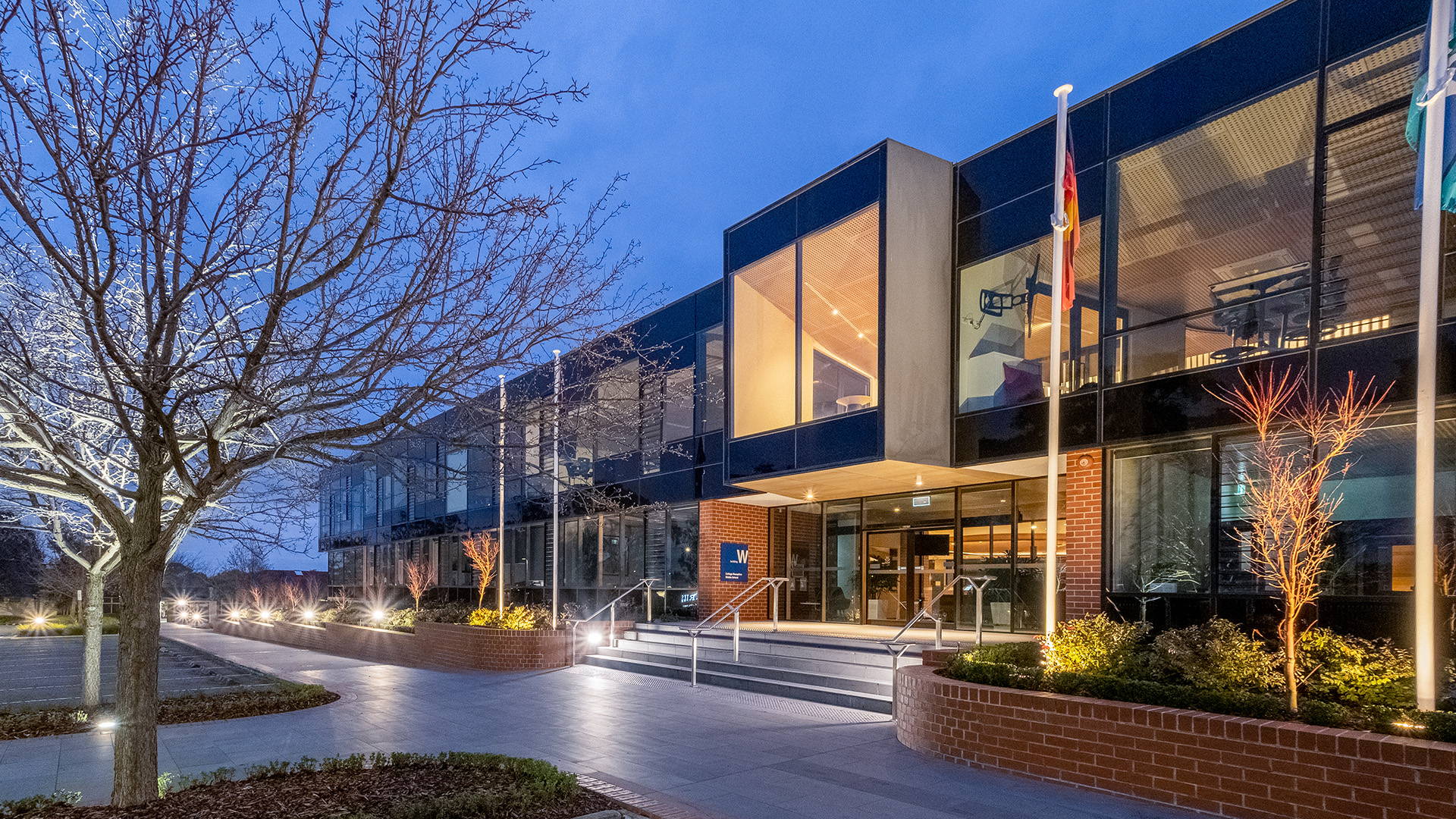 Facade view of Luther College, showcasing entry area and is illuminated by Commercial Bollard LED Lights by Havit