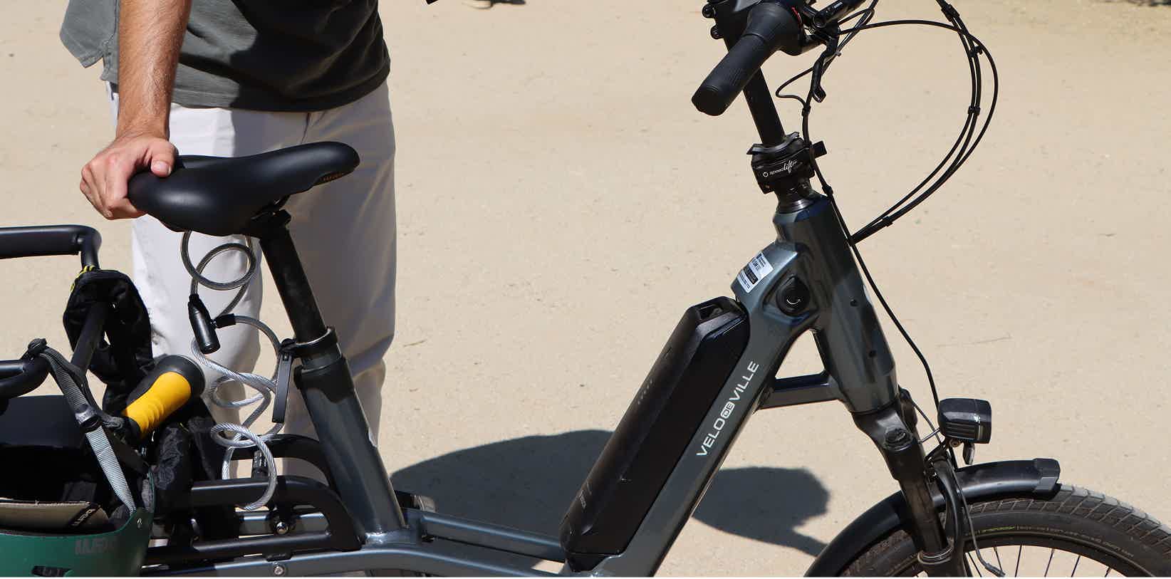 Bicicleta electrica de ciudad en barcelona bateria joven subiendo a bicicleta electrica