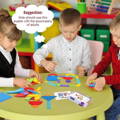 Three kids playing with sorting puzzles and creating different shapes on a table in kindergarten. 