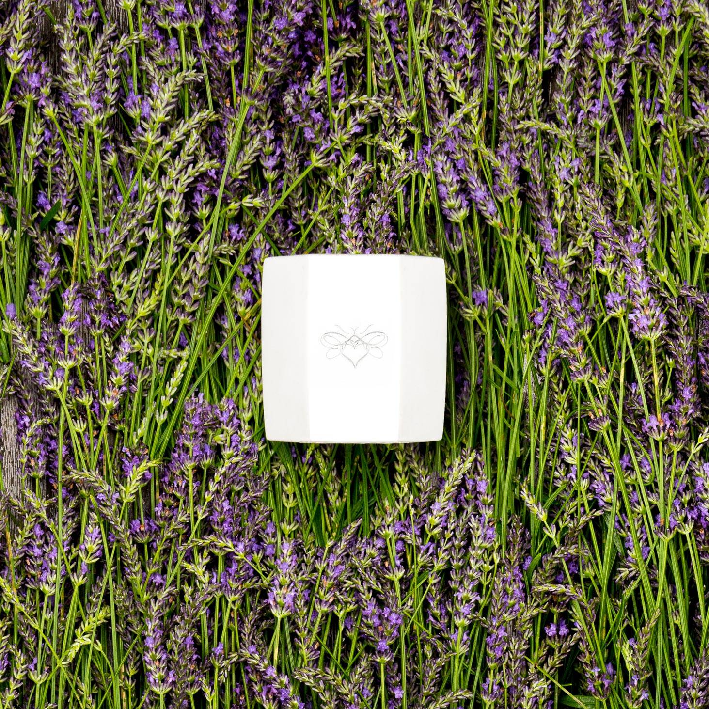 Large stone candle lying on a bed of lavender