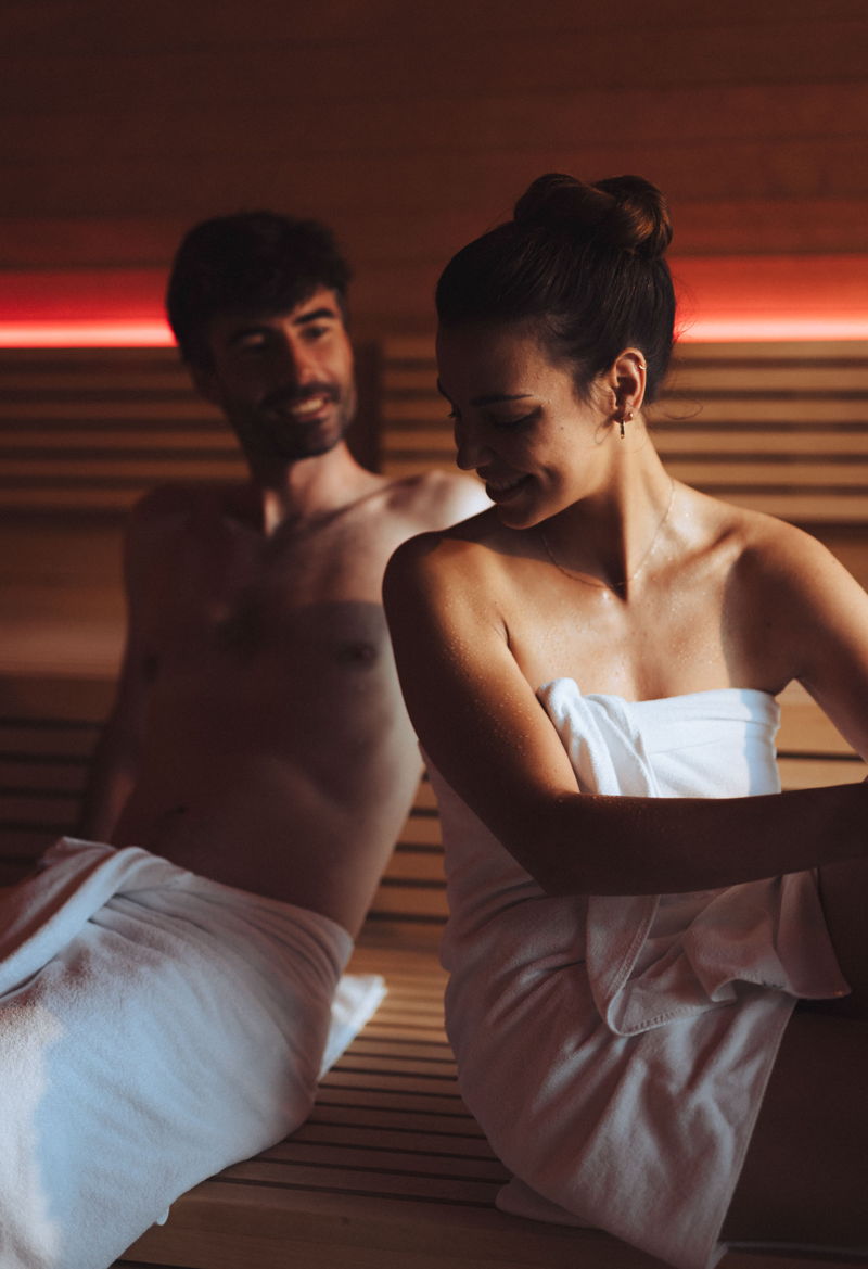 Mann mit Handtuch sitzt in der Wellnesshotel Sauna 