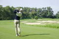 Golfer executing a balanced full swing follow-through for a straight ball flight on fairway