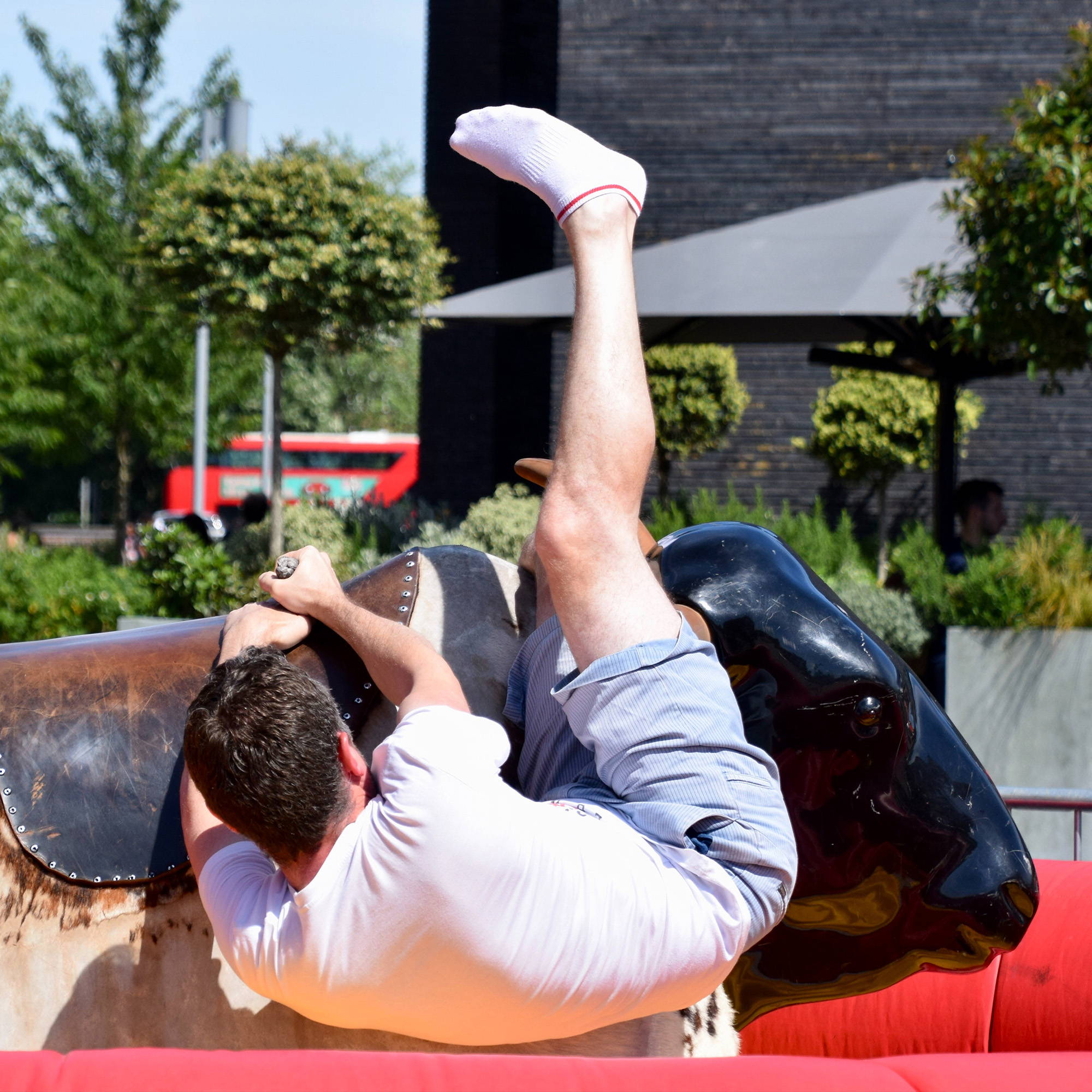 A person struggles to hold on, while riding a mechanical bull