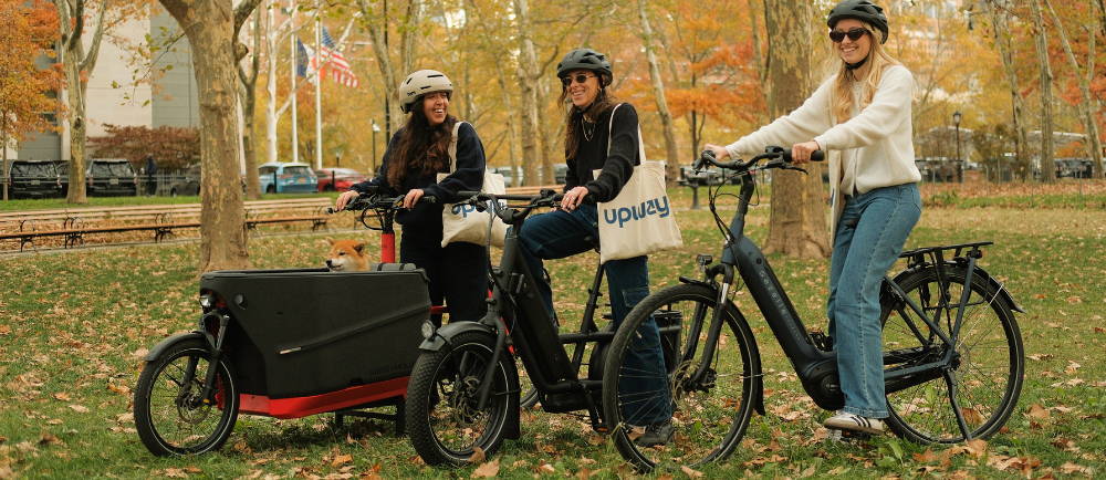 Three electric bike riders with dog in park