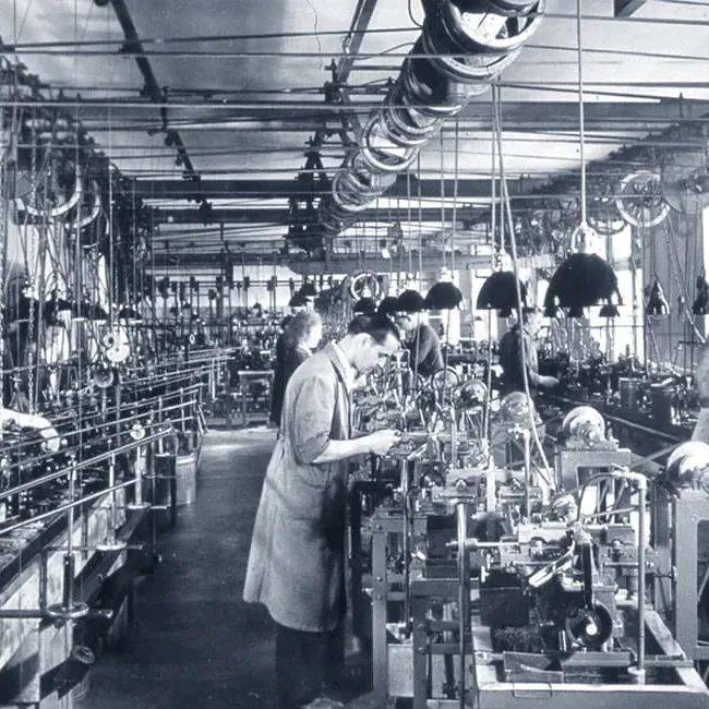 Black and white photo showing old fashion production line
