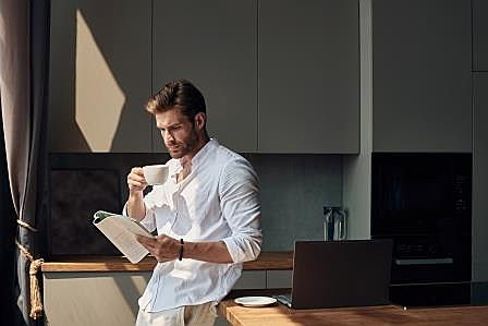  Magdeburg
- Mann zuhause in der Küche mit Kaffeetasse und Zeitung