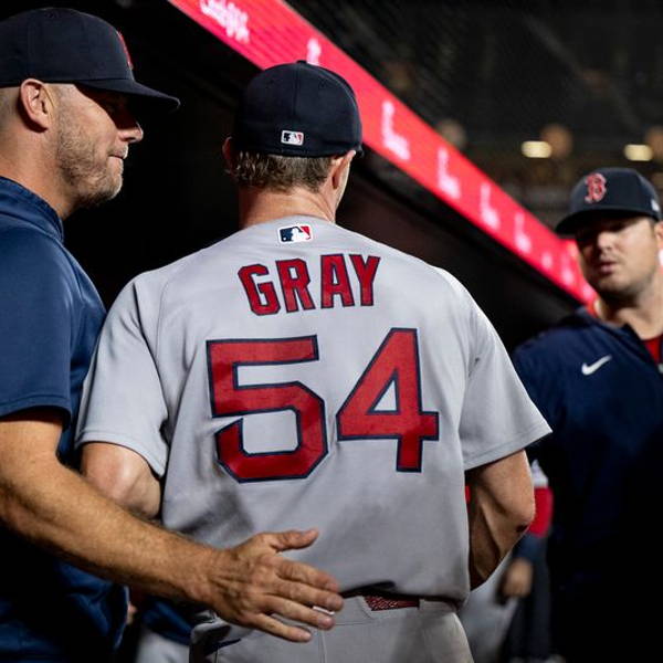 A teammate patting the Red Sox pitcher Sonny Gray on the back.