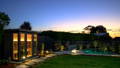 Forestville NSW Project By Havit Lighting - Backyard sauna and pool area at dusk with garden spike lights illuminating the pathway and landscaping.