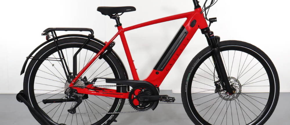 A red Gazelle Ultimate T10+ electric city bike in a city