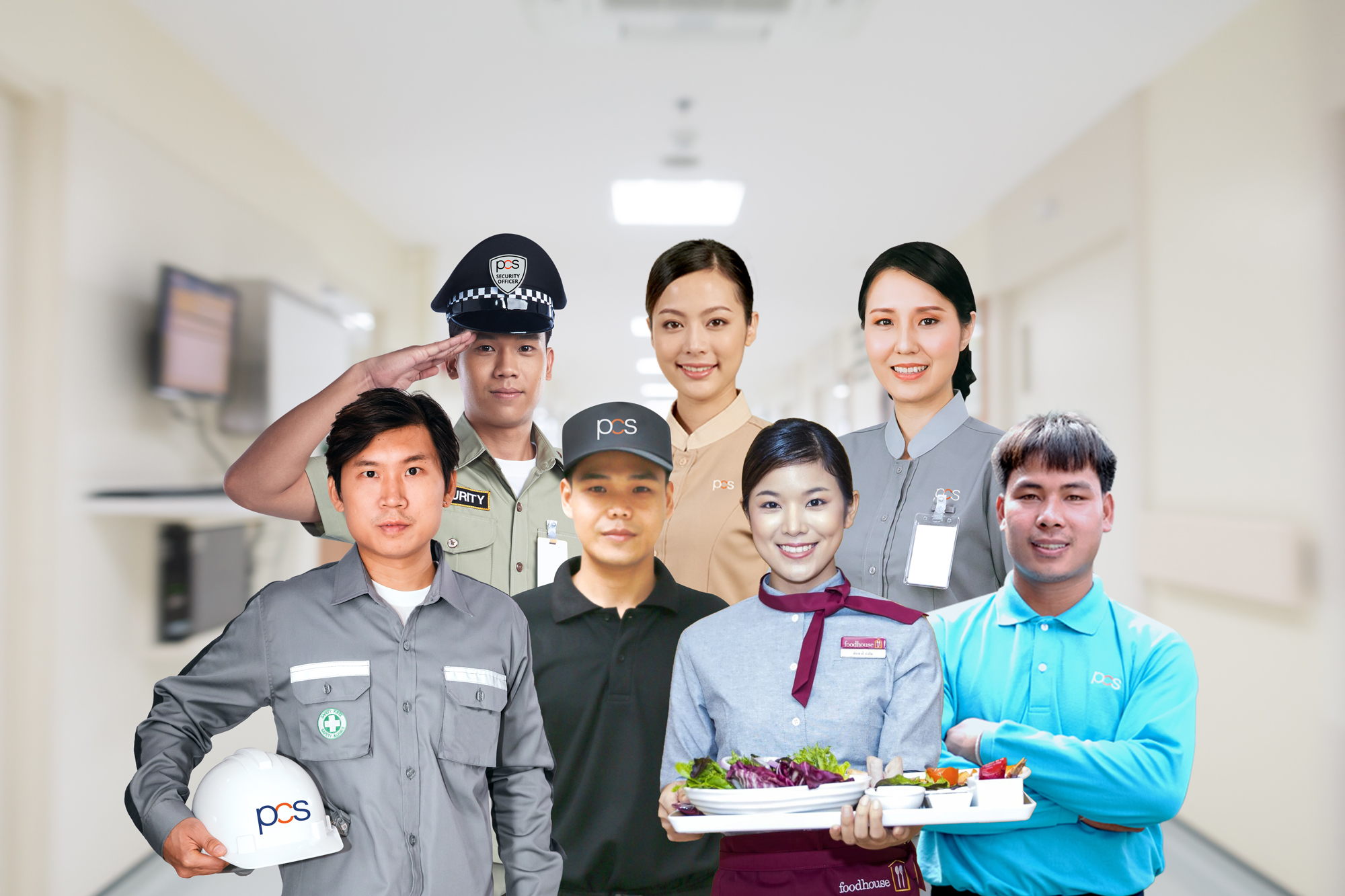 A group of seven uniformed workers from various professions stand in a well-lit hallway, smiling at the camera. One person holds a tray of food; another holds a hard hat, indicating different service roles.