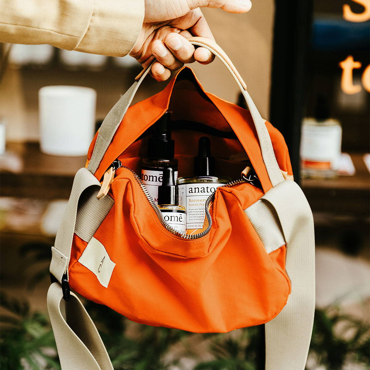 Ally Capellino P270 Pixie Crossbody Bag in Orange with Anatome products inside