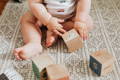Baby playing with wooden cubes.