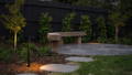 Backyard transformation featuring warm spike lighting around the seating zone.