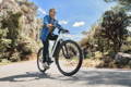 Cycliste sur VTC electrique sur une route entouré de pleine nature