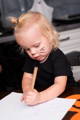 Toddler focused on an independent drawing activity at the table during screen-free play time.