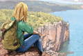 illustration of a woman wearing a summit pack at palisade head looking out over the lake and cliffs