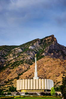 Vertical photo of the Provo Utah Temple against a desert mountains.