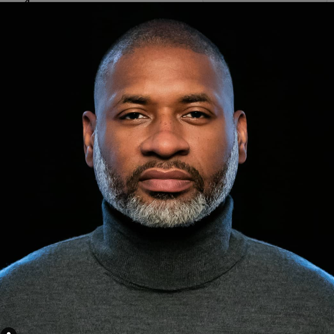 Image of Charles M Blow with a black background wearing a dark turtle neck and looking intently into the camera.