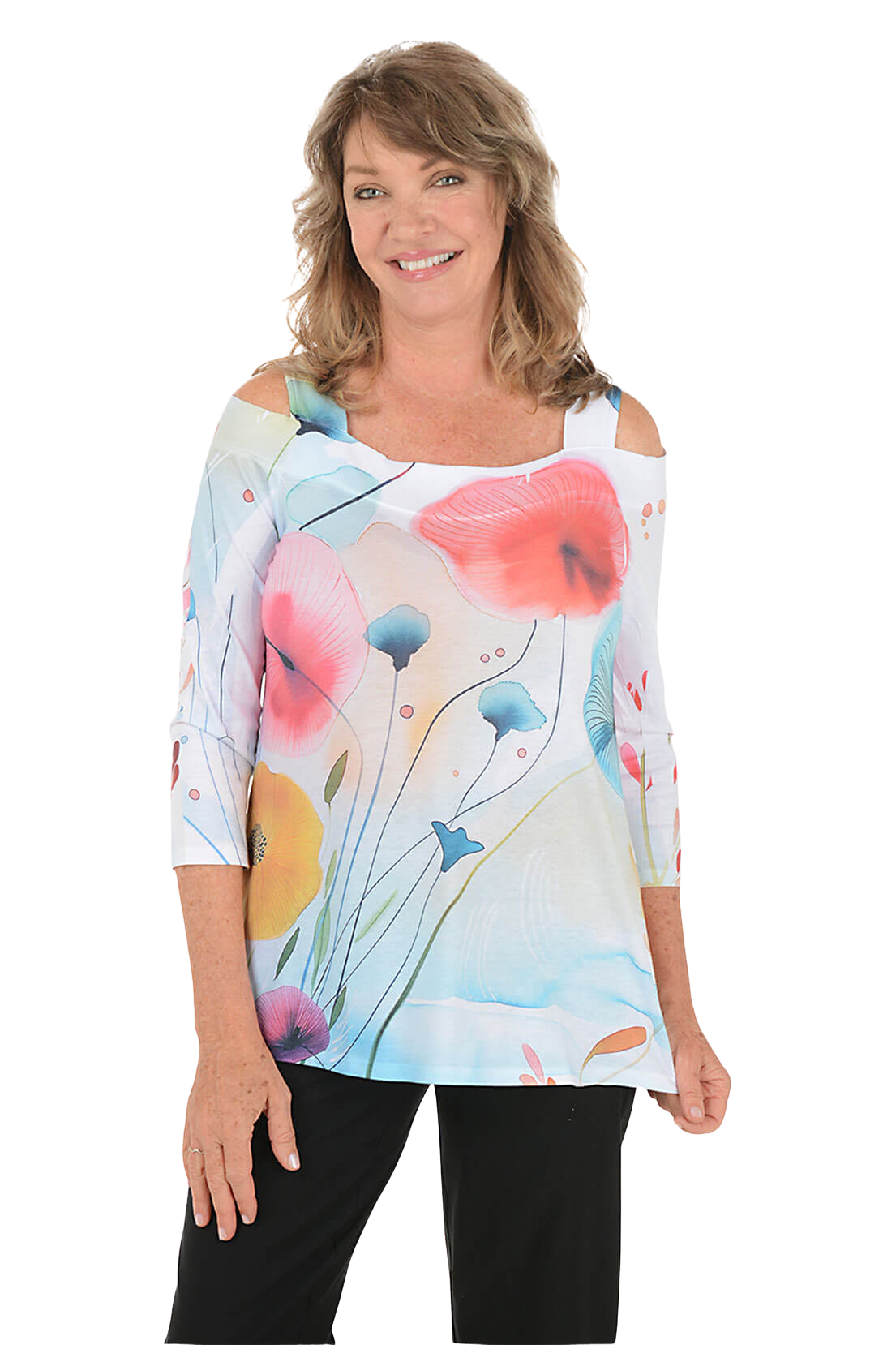 A woman wears a printed knit top with cold shoulders and a pair of black pants