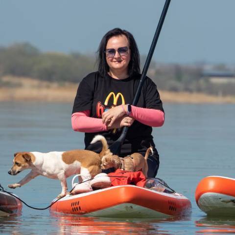 Customer blow up paddleboarding with her dog